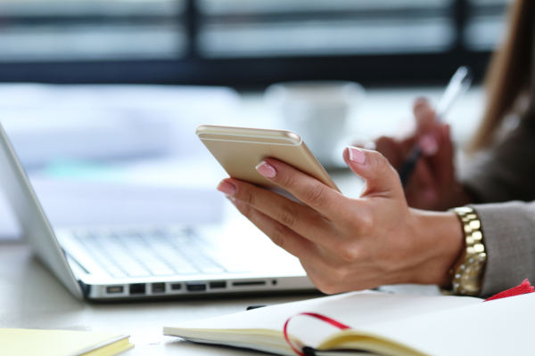 business woman sur un telephone mobile et un pc portable